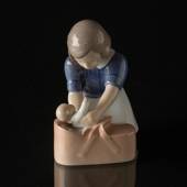 Girl with doll, gently putting it into the basket, Bing & Grondahl figurine...