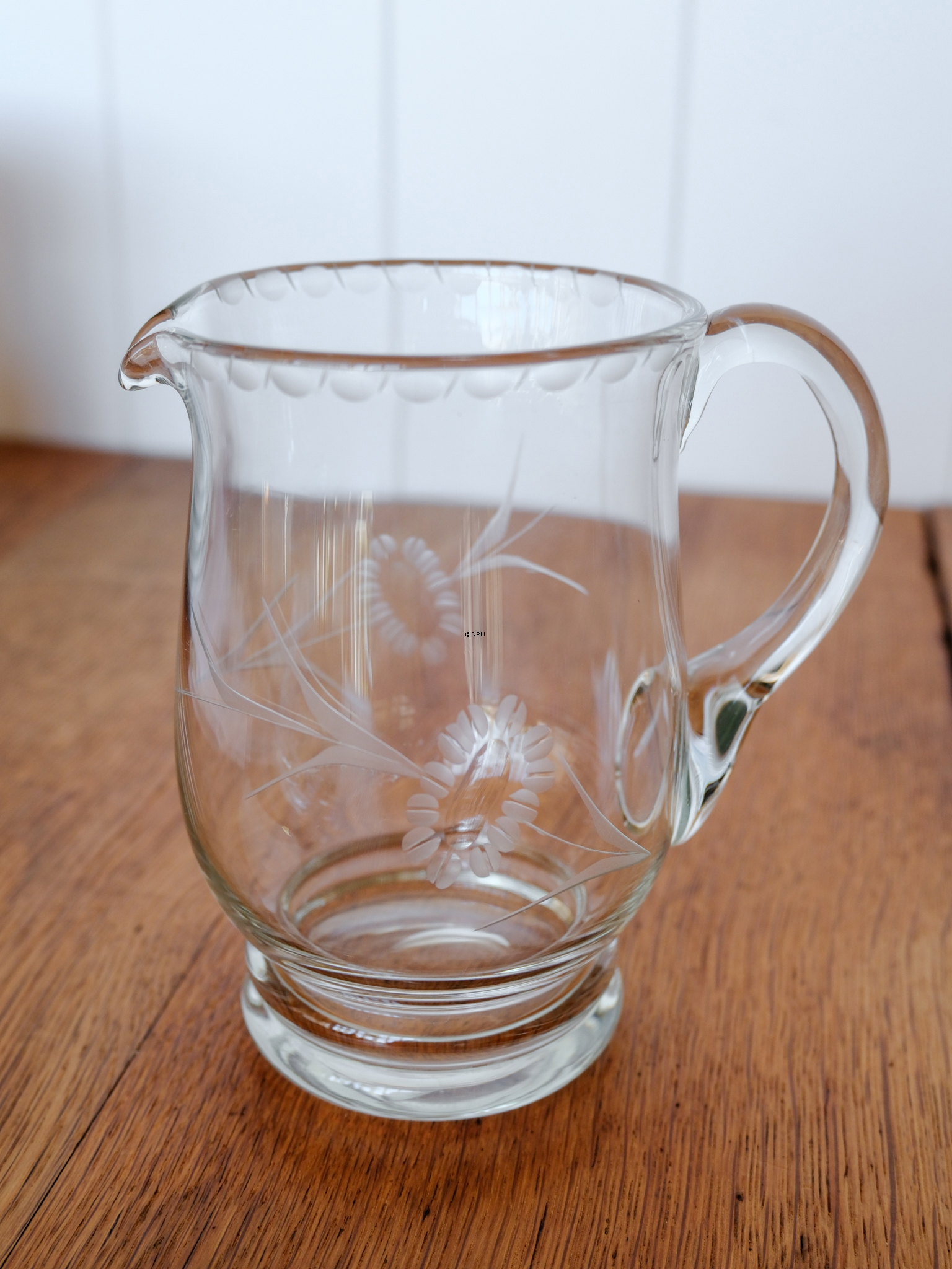 Glass jug with engravings and small foot