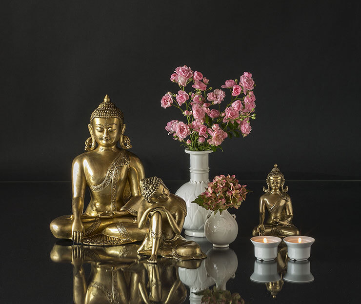 Buddha statues in an arrangement with vases and tealight candleholders