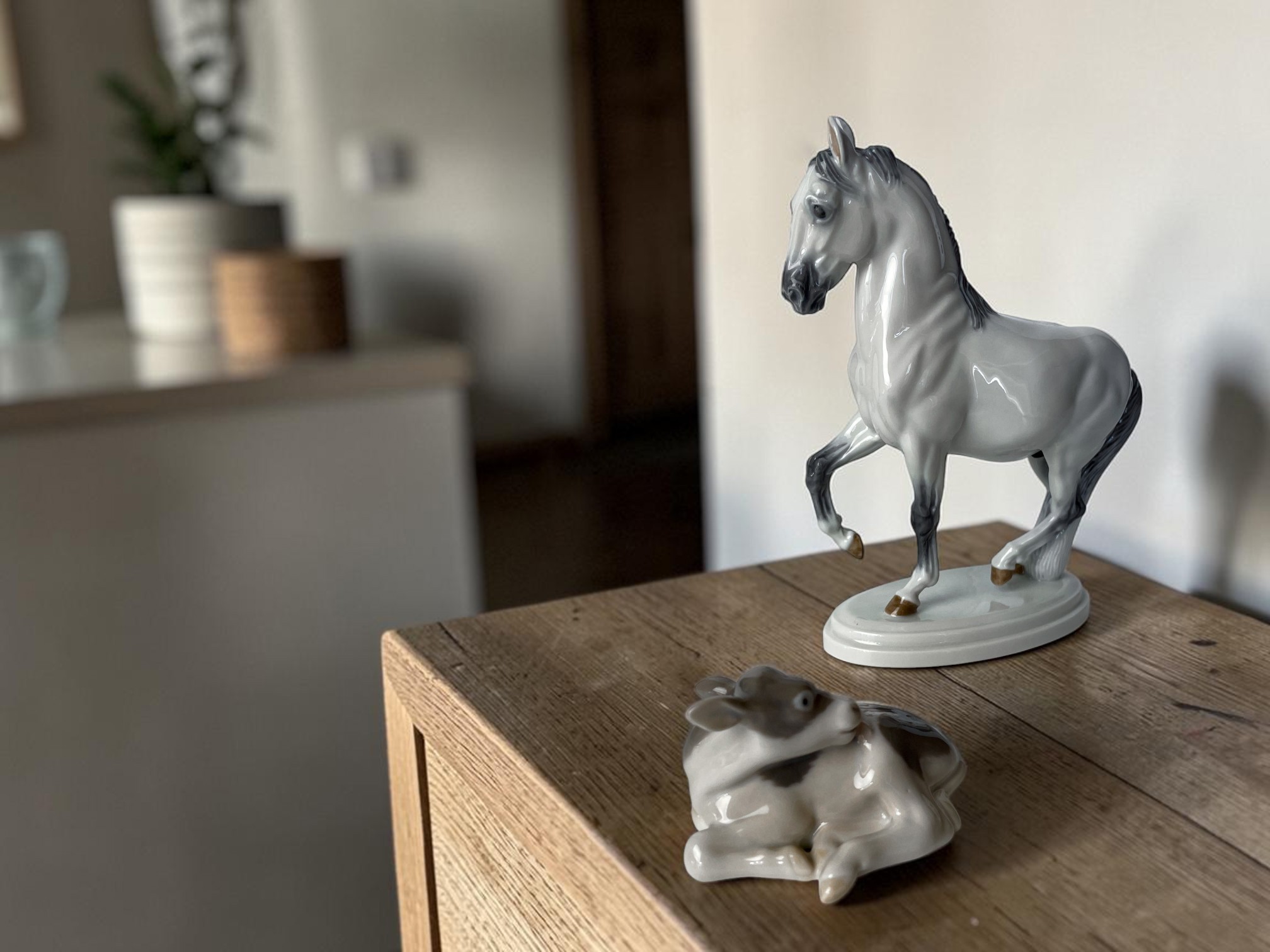 Porcelain figures of horse and cow in modern home