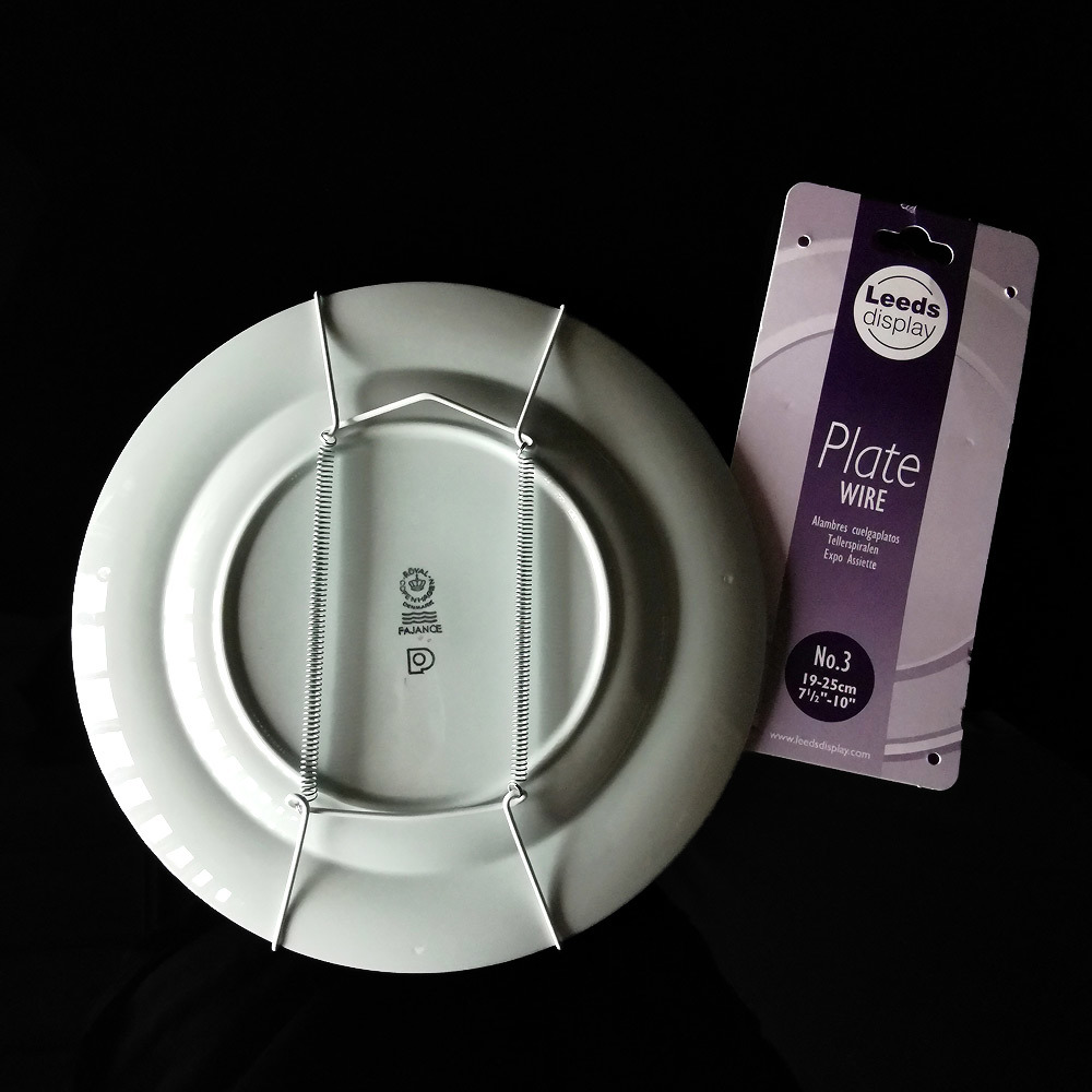 Plate hanger on the back of a plate makes it possible to hang the plate on the wall.