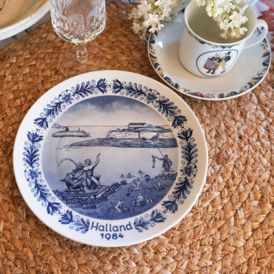Summer table set with a Seltmann Swedish landscape plate from Halland 1984 and a Rörstrand coffee cup with Swedish folk costumes. A charming setting where porcelain is mixed and matched across styles.