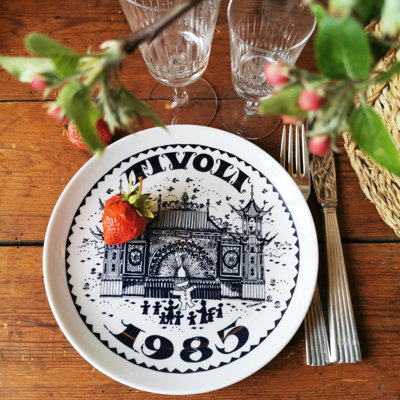 Tivoli plate from 1985 used as a dinner plate in a table setting with fresh strawberries, Lyngby glasses, and cutlery on a wooden table with summery decorations.