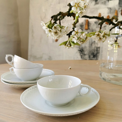 Coffee table with white Royal Copenhagen teacups and Bing & Groendahl saucers, inspiration for coffee table settings, simple table arrangements, and summer tables.