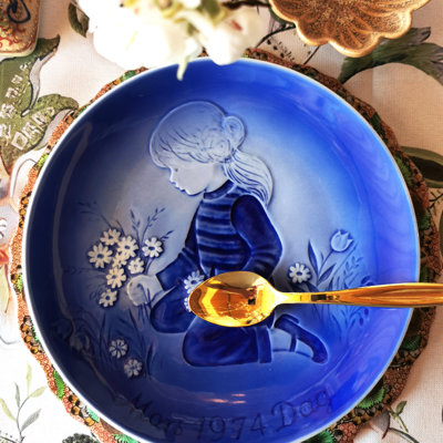 Désirée Mother’s Day plate from 1974 featuring a motif of a girl and flowers, set for a summer dessert with golden dessert cutlery.