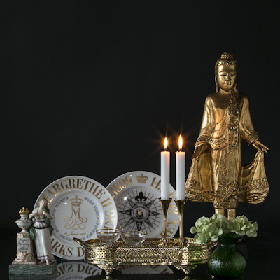 Buddha flanked by memorial plates and friendship figure behind tray with Asmussen candlesticks