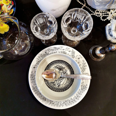Table setting in black and white with a Gustavsberg plate and a Bjørn Wiinblad bowl, combined with crystal glasses and silver cutlery.