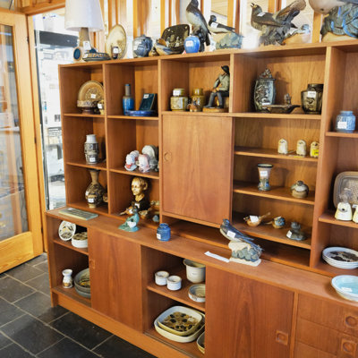 Shelf filled with ceramic figurines, vases, dishes, and bowls from Bing & Groendahl, Royal Copenhagen, Söholm, Johgus, and Michael Andersen & Son – displayed at the Danish Porcelain House store in Odense, Denmark.
