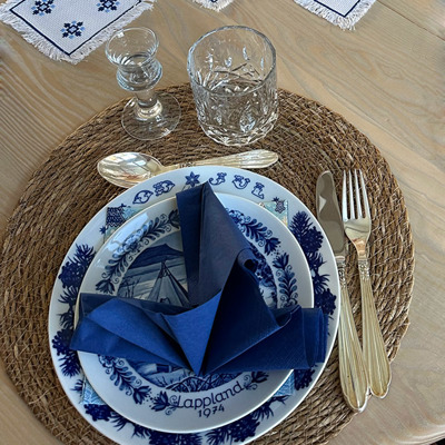 A charming Christmas table setting in blue and white, combined with gold cutlery and a blue napkin.