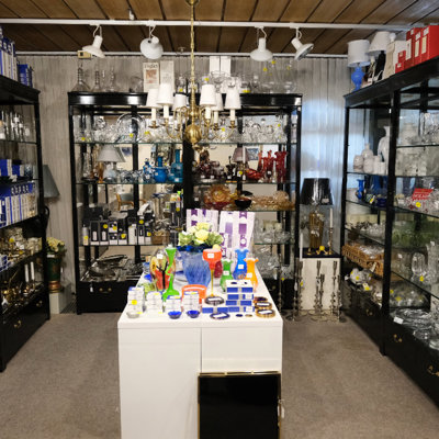 Wide selection of glassware, crystal, vases, and gift items at the Danish Porcelain House store – filled display cabinets and a central table with colorful home décor.
