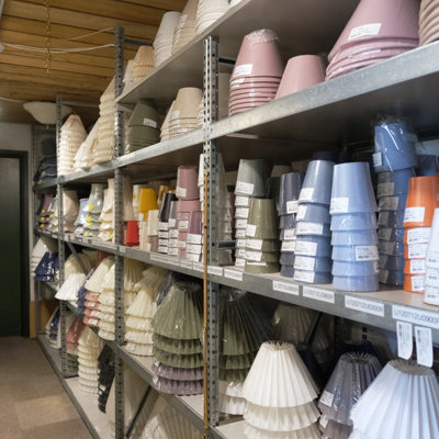 Shelves filled with lampshades in many colors and sizes at the Danish Porcelain House in Odense, Denmark – from classic pleated shades to modern smooth designs.