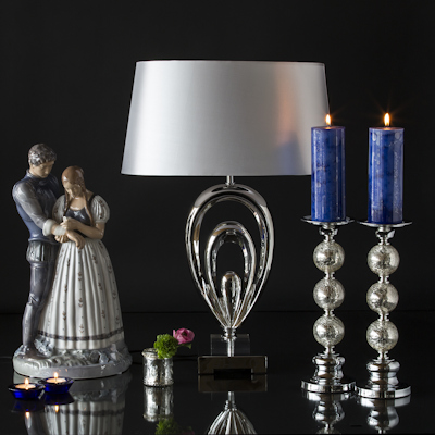 Large knight and maiden figure next to glass lamp and candlesticks