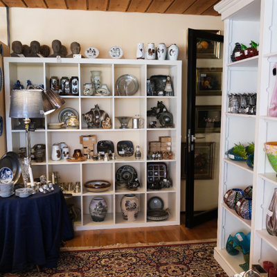 Shelves with ceramics at the Danish Porcelain House – stoneware, vases, dishes, and figurines in various styles and colors.